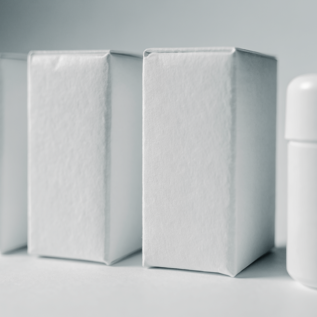 Three unlabelled product cartons side by side on a plain surface